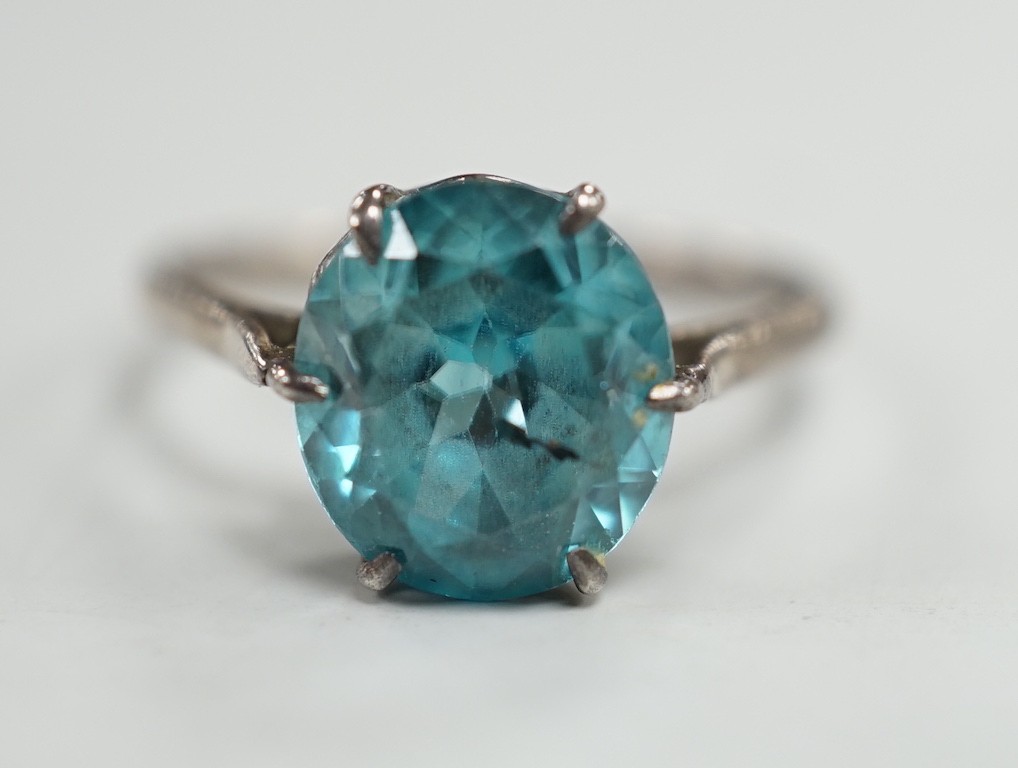 A white metal and blue zircon set ring, size P/Q, gross weight 2.8 grams.